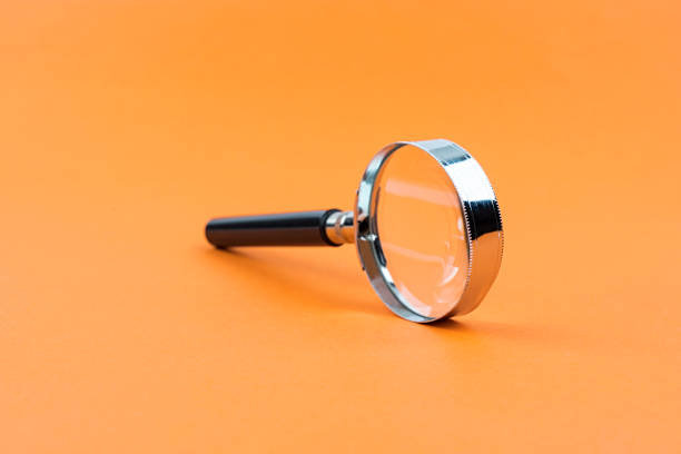 istock Magnifying glass isolated orange background 1201983256