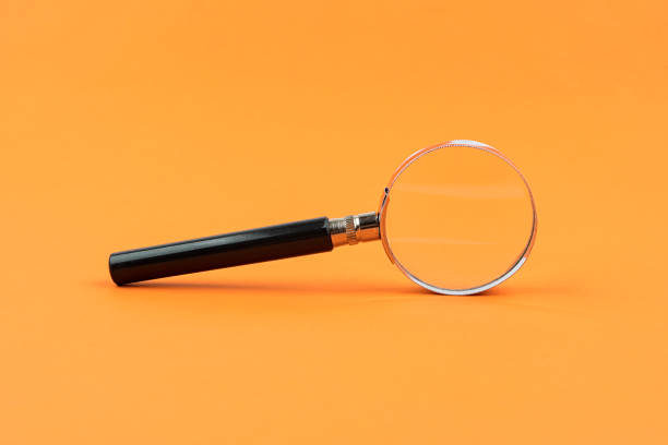 istock Magnifying glass isolated orange background 1201983287