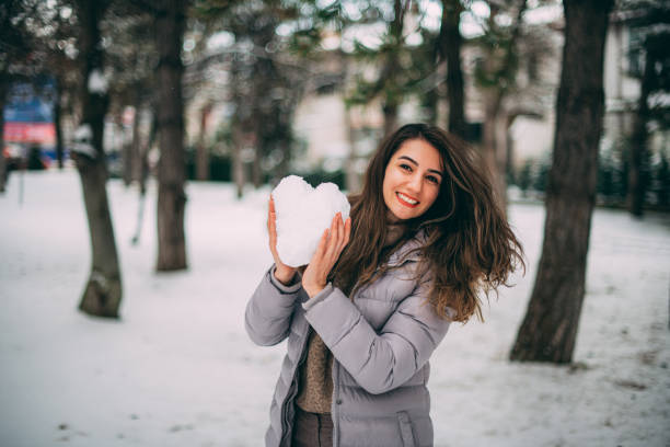 istock Woman Making Heart From Snow 1202000707