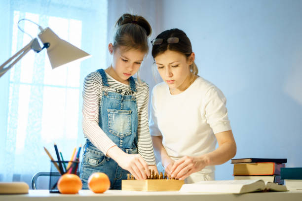 istock Mother and daughter are playing chess while spending time together at home 1202003636