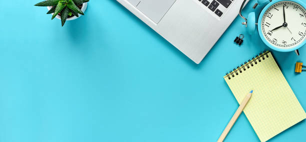 istock Office workspace desk. Notepad, laptop and alarm clock. View from above with copy space. 1202004174