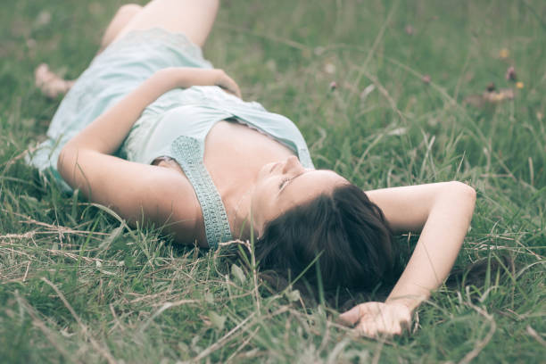 cute young woman lying on grass on summer day. Enjoy nature