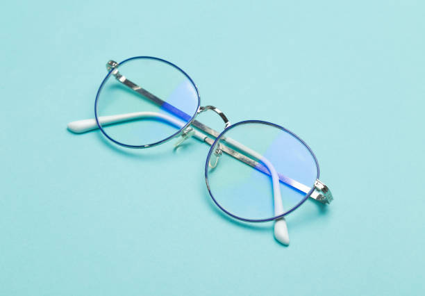 Eye glasses isolated on blue background Eye glasses isolated on blue background. optometry photos stock pictures, royalty-free photos & images