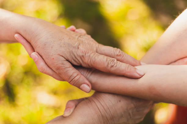 istock Close-up shot of holding hands outside 1202010944
