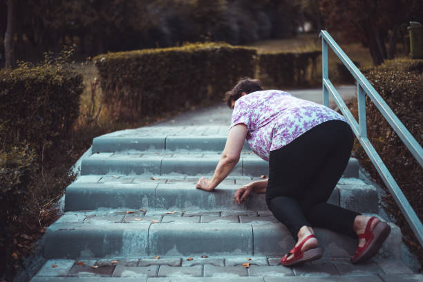 Senior woman fall on stairs outside stock photo