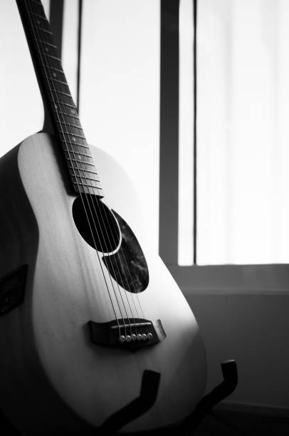 istock Acoustic guitar resting on guitar stand hanger with black and white tone 1202020247