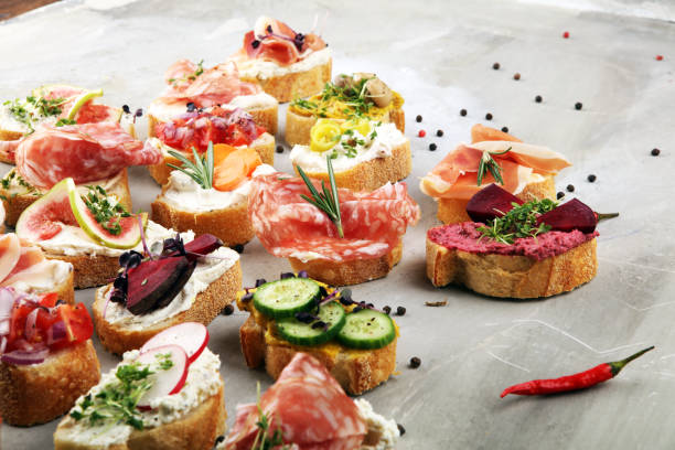 istock Assorted bruschetta with various toppings. Appetizing bruschetta or brie crostini. Variety of small sandwiches. Mix bruschetta on table 1202021625