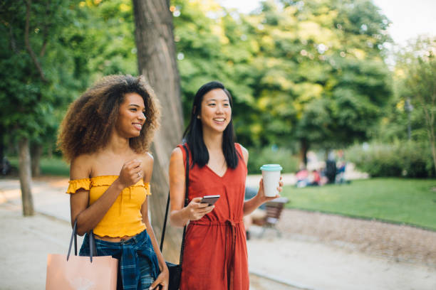 istock Beautiful girls walking together and using mobile app 1202021886
