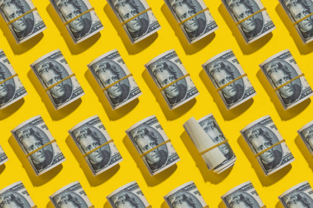 dollar rolls flat lay on yellow background - money roll imagens e fotografias de stock