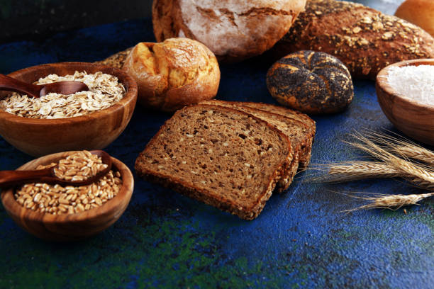 istock Assortment of baked bread and bread rolls and cutted bread on table background 1202025255