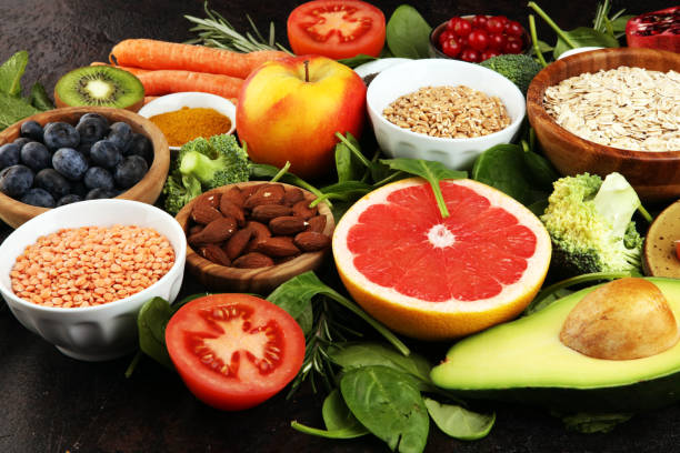 istock Healthy food clean eating selection: fish, fruit, vegetable, cereal, leaf vegetable on rustic background 1202025394
