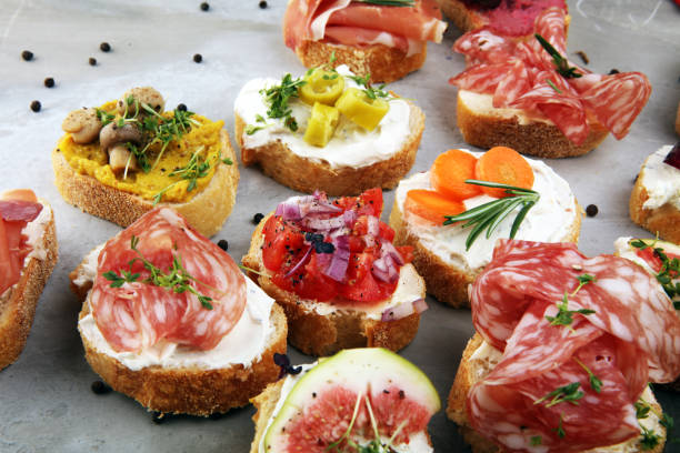 istock Assorted bruschetta with various toppings. Appetizing bruschetta or brie crostini. Variety of small sandwiches. Mix bruschetta on table 1202026759