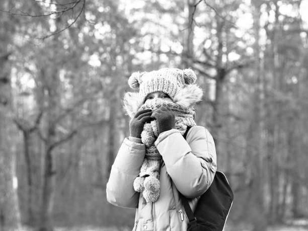 A close up portrait of a beautiful 16 year old girl smiling at the camera in winter. Some copy space in snow.