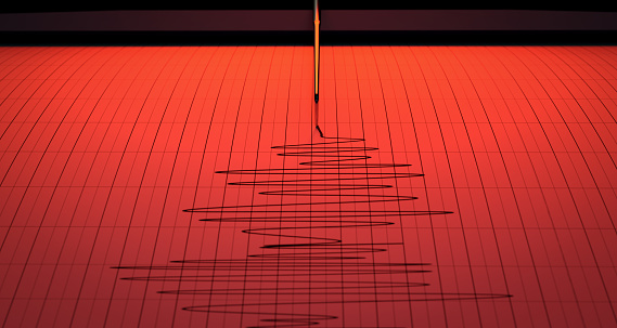 Alerta roja de un primer plano de una aguja de máquina de sismógrafo dibujando un papel gráfico que representa la actividad sísmica y sísmica photo