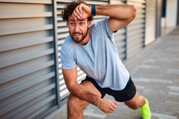 istock Young man exercising / stretching in urban area. 1202030755