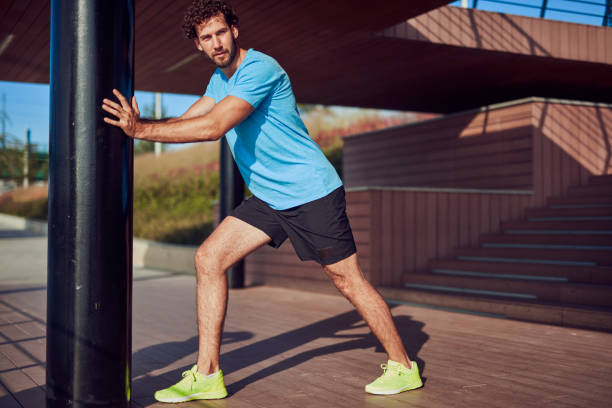 istock Young man exercising / stretching in urban area. 1202030773
