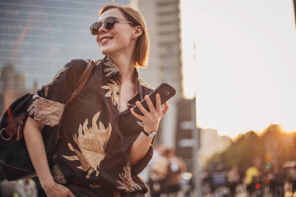 istock Stylish young woman is text messaging 1202033536