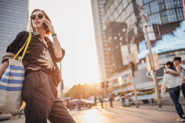 istock Cheerful young woman is talking on phone 1202034199