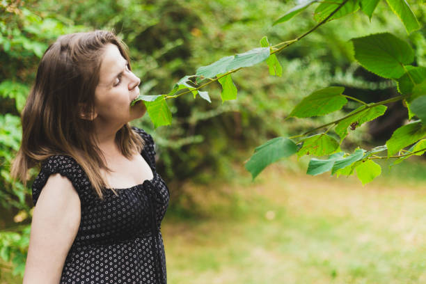 istock Young woman eating leaves from a tree 1202036589