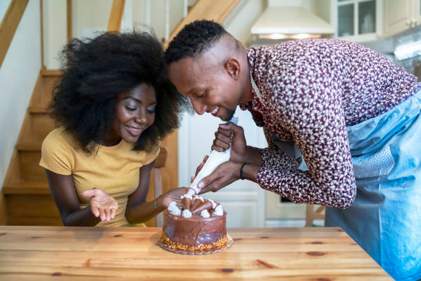 istock African couple decorating birthday cake at home 1202038156