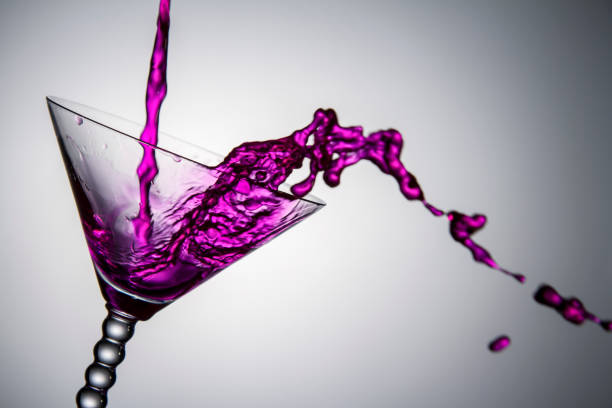 Shaped Pouring Purple Liquid Into Glass stock photo