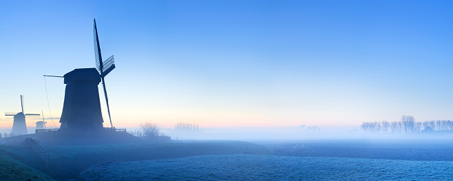 Traditional Dutch windmills on a beautiful frosty and foggy morning. A seamlessly stitched panoramic image with a total size of 64 megapixels.