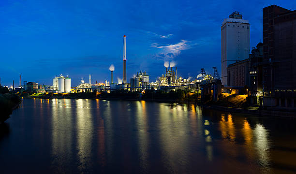 химический завод в ночное время - factory night skyline sky стоковые фото и изображения