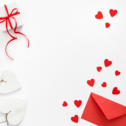 Gift box, hearts decoration and red envelope. Valentineâs Day flat lay