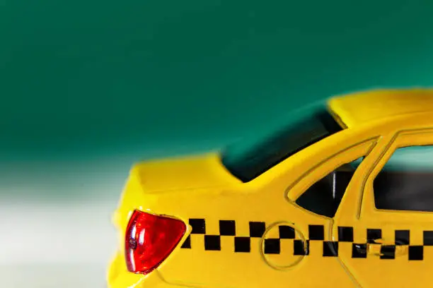 Yellow taxi close up on a green backgrounds