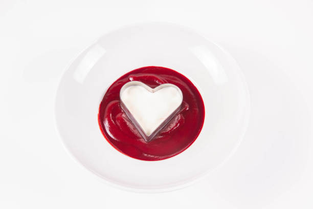 Beetroot cream soup decorated with a heart made of cream being made