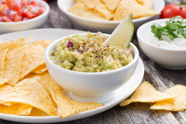 guacamole, tomato salsa and corn chips guacamole, tomato salsa and corn chips, horizontal fresh cilantro stock pictures, royalty-free photos & images