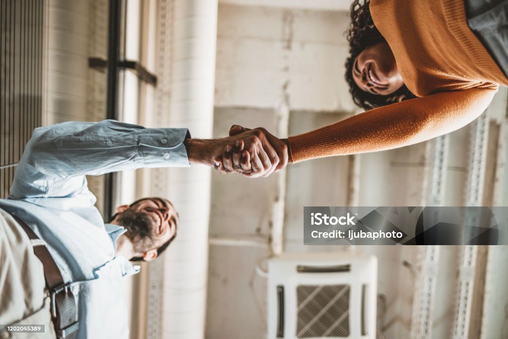 Two people shaking hands Sealing a deal! Two Business people shaking hands after Welcoming partners finishing up a meeting or setting goals and planning way to success in the office. Customer Stock Photo
