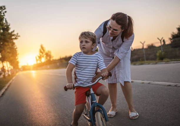 istock Mom teaching her son biking 1202046408