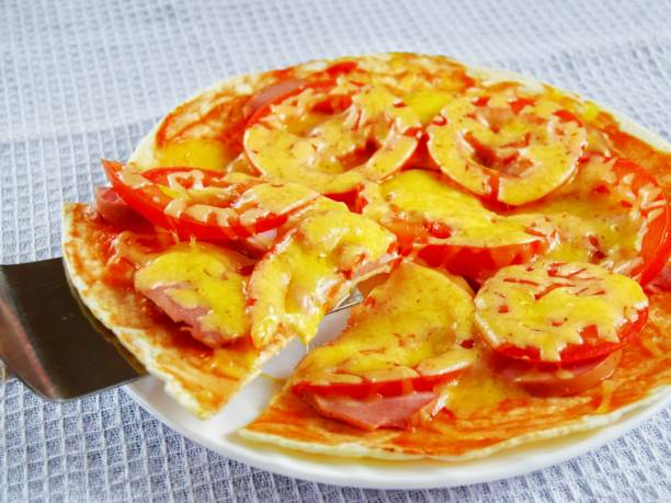 ready-made pizza with a cut slice on a food spatula on a white plate instead of a white towel background. close up