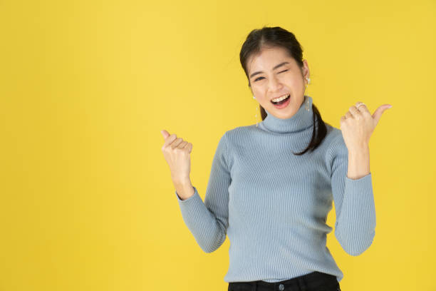 istock Women with thumbs pointing on both sides 1202048723