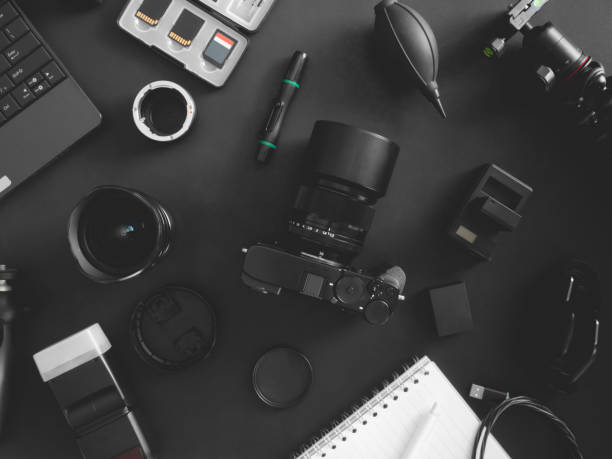 istock top view of work space photographer with digital camera, flash, cleaning kit, memory card, tripod and camera accessory on black table background 1202052763