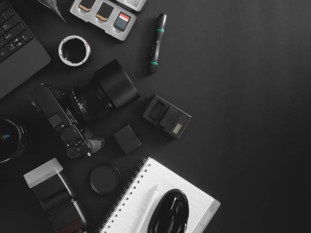 istock top view of work space photographer with digital camera, flash, cleaning kit, memory card, tripod and camera accessory on black table background 1202052795