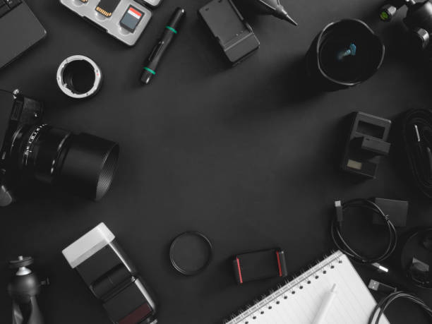 istock top view of work space photographer with digital camera, flash, cleaning kit, memory card, tripod and camera accessory on black table background 1202052796