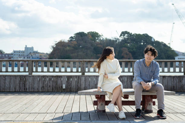 istock A young couple sitting on a bench and having a fun conversation 1202057179
