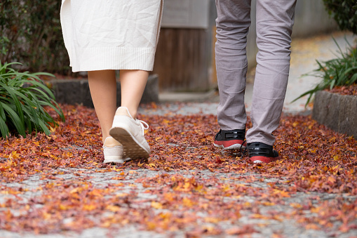 Back view of young man and woman with autumn leaves