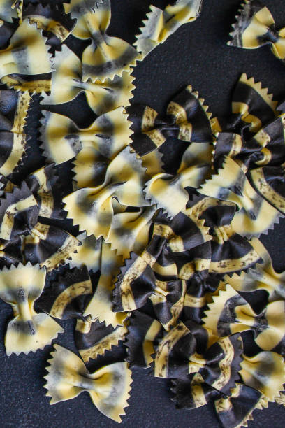 istock pasta farfalle cuttlefish ink (healthy eating, black multi-colored) menu concept. food background. top view. copy space 1202058753