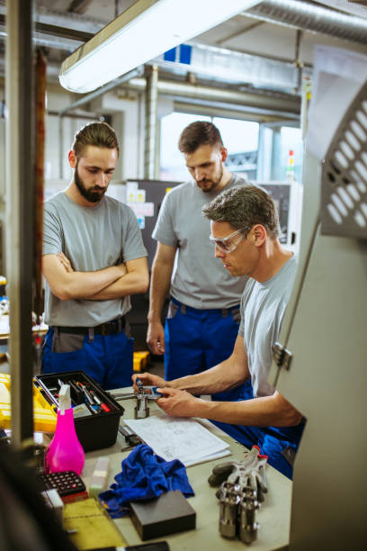 istock Male supervisor evaluate work in factory and writing at notepad 1202061507