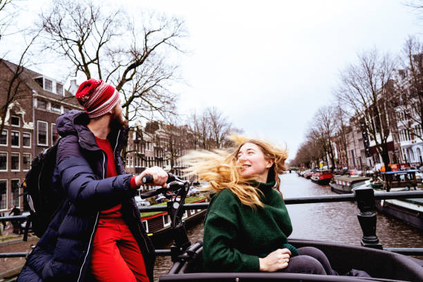 アムステルダムの路上で楽しんで愛するカップルの男と女 - long hair red hair women men ストックフォトと画像