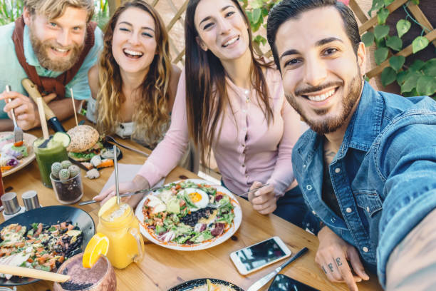 istock Happy friends taking selfie with mobile smartphone while lunching in coffee brunch restaurant - Young trendy people having fun eating together - Youth lifestyle food culture concept 1202062879
