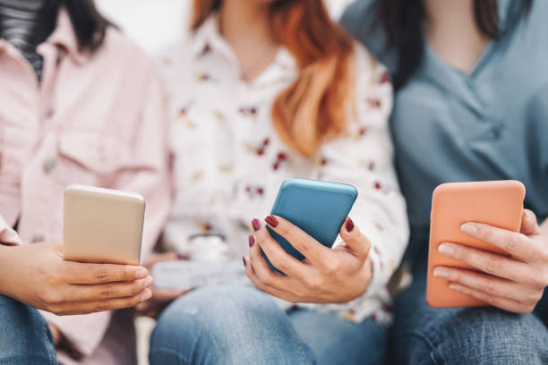 istock Group friends using mobile smartphone outdoor - Millennial young people having fun with new social media technology - Youth generation tech addiction and team marketing concept 1202062931
