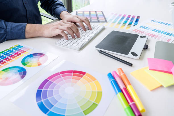istock Image of male creative graphic designer working on color selection and drawing on graphics tablet at workplace with work tools and accessories 1202062998