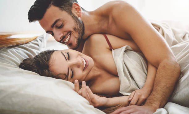 happy couple having fun on bed under blanket - young romantic lovers intimate moments - intimacy and love relationship concept - infidelity sensuality couple men imagens e fotografias de stock