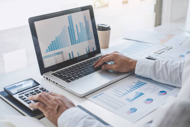 istock Professional at work, businessman working and analyzing on laptop with calculate statistics of financial document data graph for new project of business strategy and market growth at workplace 1202063026