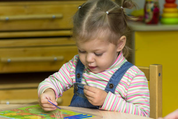 カウントスティックで遊ぶ白人の子供の肖像画2歳 - fine motor skills ストックフォトと画像