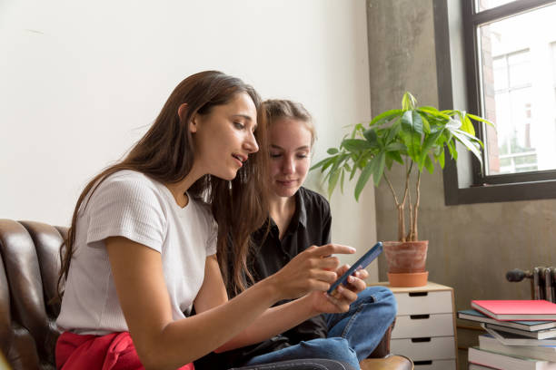 istock Two Young Women Looking at Smartphone Indoors 1202066399